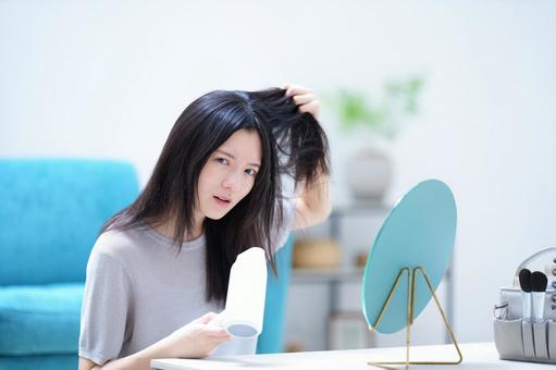 怖い顔で髪を持ちカメラ目線の女性 女性,ドライヤー,髪の写真素材