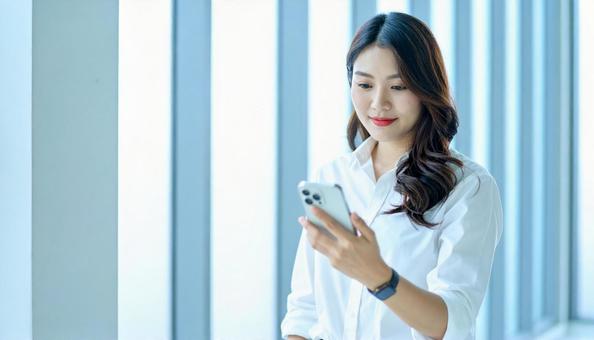スマホを確認するビジネス女性 スマホを確認するビジネス女性の写真