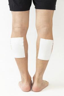 湿布を貼った男性の脚 白バック 湿布を貼った男性の脚 白バック 男性,脚,足の写真素材
