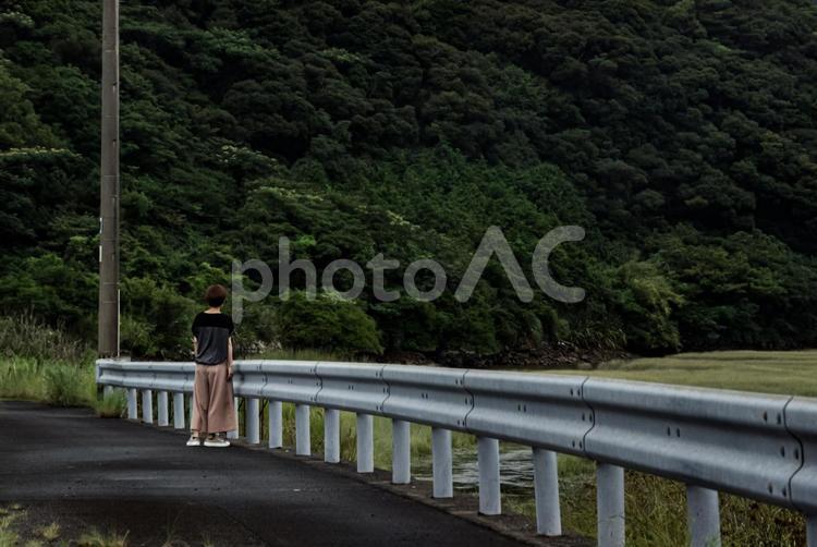 ＜素材＞雨上がり田舎の川沿いを歩く女性 女性,雨上がり,散歩の写真素材