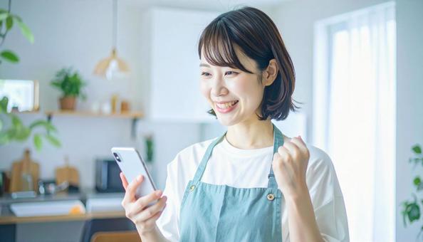 スマホでポイ活する笑顔の女性 スマホでポイ活する笑顔の女性の写真