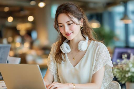 オフィスでPCを使用して仕事中の女性 オフィスでPCを使用して仕事中の女性の写真