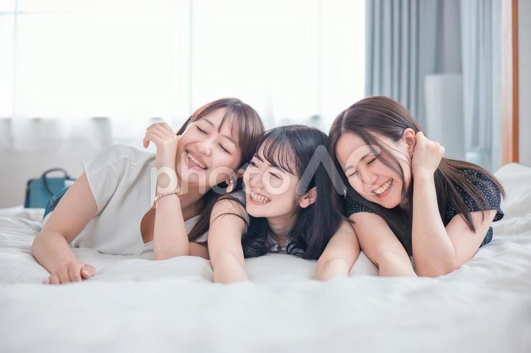 旅行の宿泊先に着いた女性たち（ベッド） 旅行,旅,女子旅の写真素材