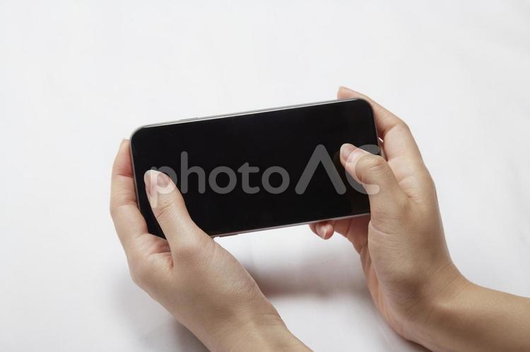 スマホを操作してゲームをする女性の手 アクション,アプリ,インターネットの写真素材