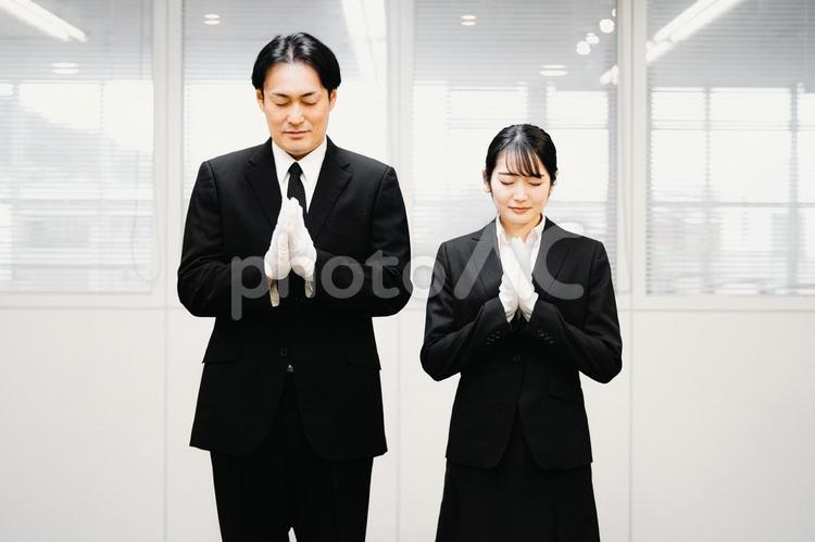 合掌する白手袋をつけた礼服姿の男女 葬祭ディレクター,白手袋,礼服の写真素材