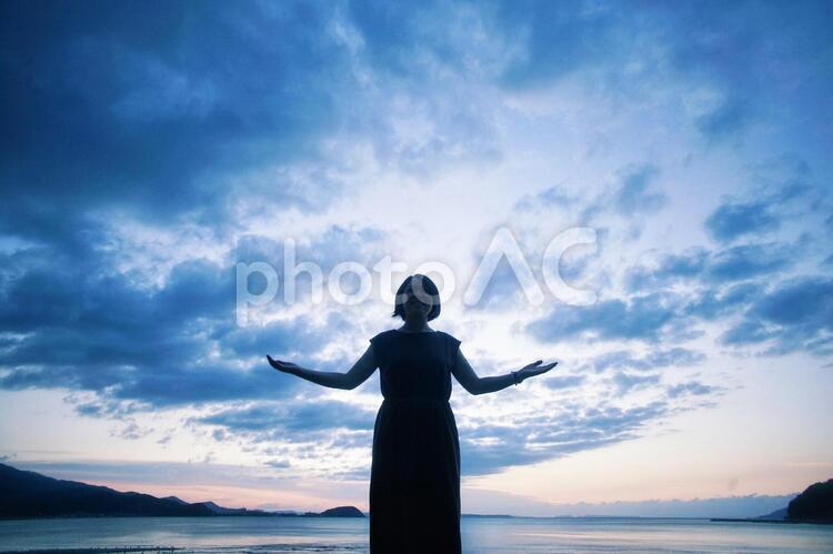 夕日と女の子のシルエット 暗い,青,夕陽の写真素材