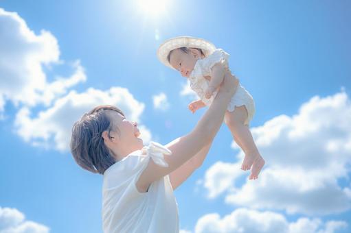 太陽と青空と親子 太陽と青空と親子 母親,赤ちゃん,親子の写真素材