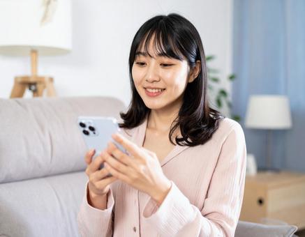 スマホを操作する女性の写真