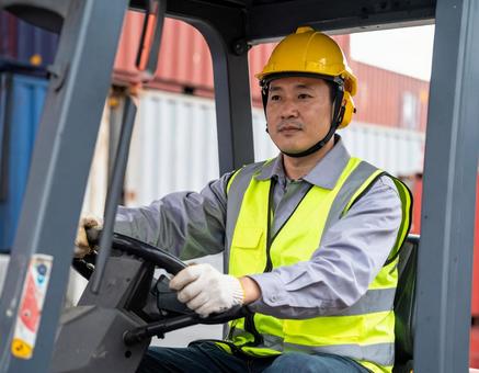 フォークリフトを運転する男性作業員の写真
