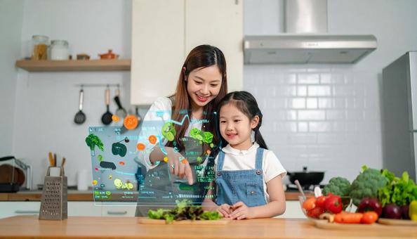 ホログラムで野菜の切り方を学ぶ親子 ホログラムで野菜の切り方を学ぶ親子の写真