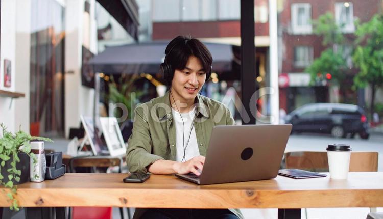 カフェで仕事をするフリーランス男性 男性,コワーキングスペース,コワーキングの写真素材