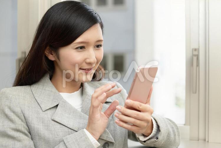 スマートフォンを持つ笑顔の女性 女性,ビジネスウーマン,女の写真素材