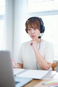 顎に手を当てパソコンを見つめる女性 女性,ノートパソコン,見るの写真素材