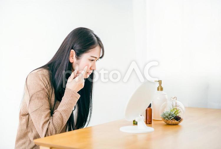 鏡の前で肌に悩む女性（頬） ニキビ,肌荒れ,鏡の写真素材