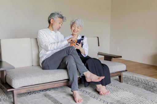 スマホを見て笑うシニアカップル スマホ,スマートフォン,検索の写真素材