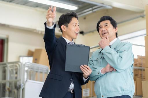倉庫で商談をする経営者とビジネスマン 倉庫で商談をする経営者とビジネスマン 会議,倉庫,工場の写真素材