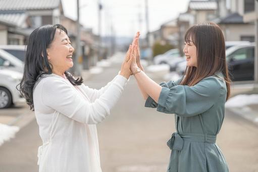 ハイタッチする女性 ハイタッチする女性 ご近所付き合い,隣人,女性の写真素材