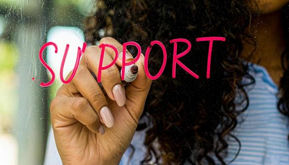 文字「Support」と赤ペンで書く手元 文字「Support」と赤ペンで書く手元の写真