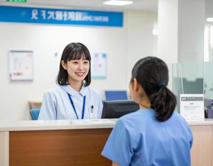 病院の受付コーナーで笑顔で迎える受付嬢 病院の受付コーナーで笑顔で迎える受付嬢の写真