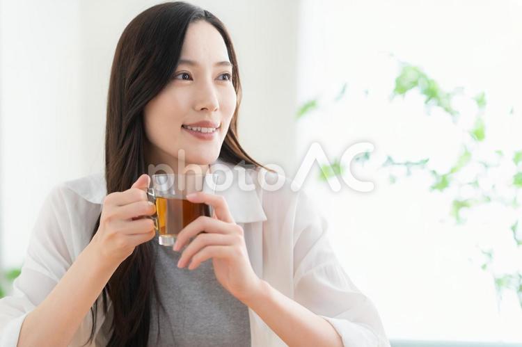 リビングでお茶を飲む若い女性 女性,紅茶,ライフスタイルの写真素材