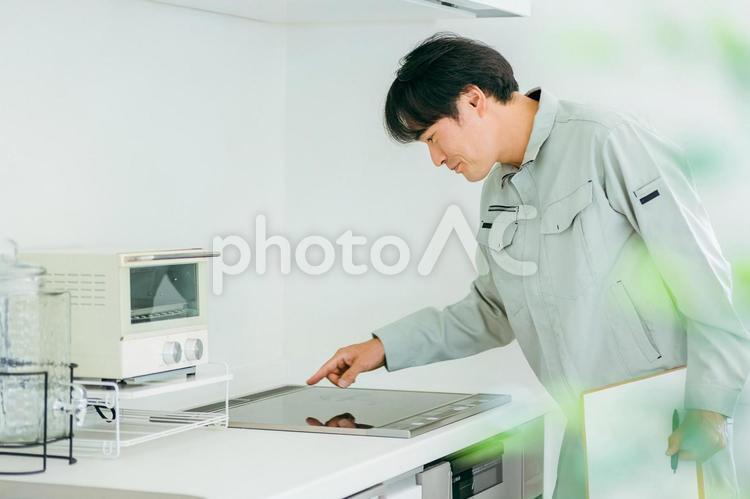 キッチンと作業着姿の男性（IH） ih調理器,ih,ihクッキングヒーターの写真素材