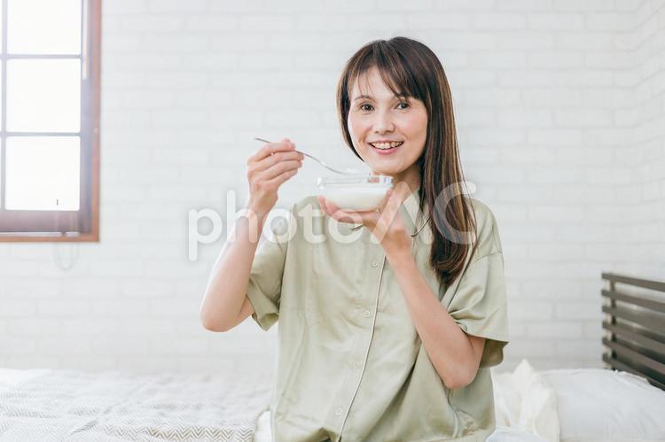 寝室でヨーグルトを食べるミドル世代の女性 ヨーグルト,乳酸菌,菌活の写真素材