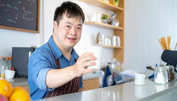 カフェで働くダウン症の男性の笑顔 カフェで働くダウン症の男性の笑顔の写真