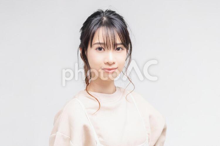 白い背景の前に立ってポーズをとる若い女性 女性,白背景,立つの写真素材