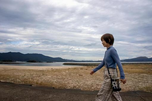 ＜素材＞秋の海辺をウォーキングする女性 女性,海,ウォーキングの写真素材