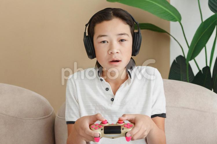 ポカンとして集中してゲームする男性 男性,人物,高校生の写真素材