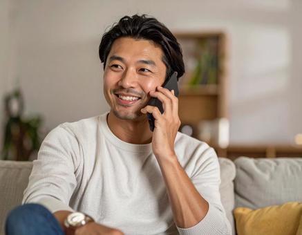 自宅で通話をする男性 自宅で通話をする男性の写真