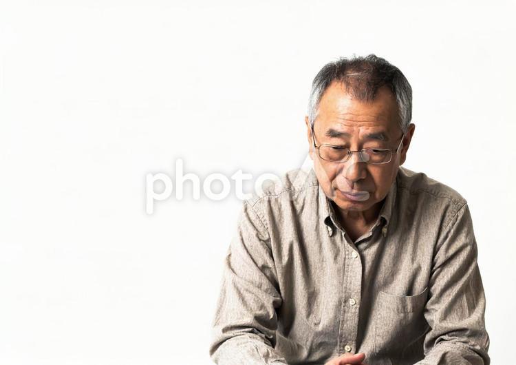 うつむいて悩む高齢男性（白背景） 男性,高齢者,シニアの写真素材