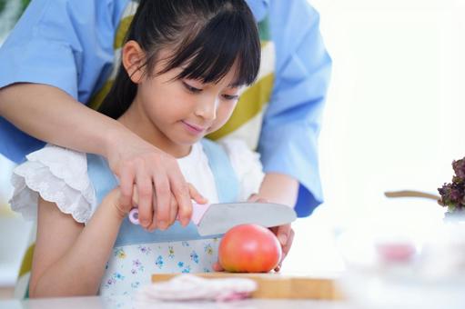 料理を手伝う女の子と見守る大人 女の子,トマト,野菜の写真素材