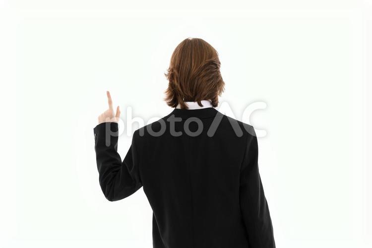 左手でポーズする人の後ろ姿（上半身） 後ろ姿,指差し,一番の写真素材