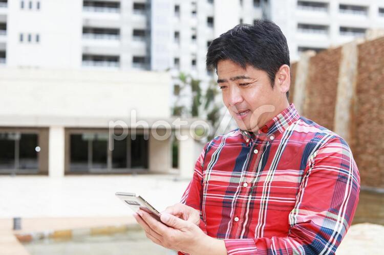 スマートフォンを持つ笑顔の男性 男性,男,笑顔の写真素材