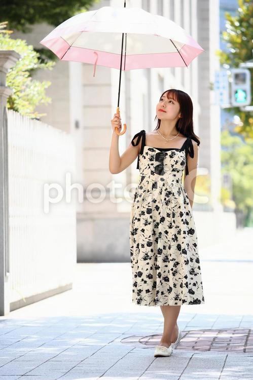日傘をさして舗道を歩く女性 女性,美人,日傘の写真素材