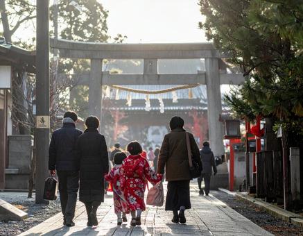 神社へ初詣に向かう家族の後ろ姿 神社へ初詣に向かう家族の後ろ姿の写真