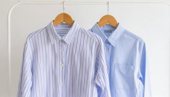 ハンガーに掛けたシャツ2枚と壁面収納の写真