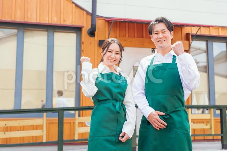 お店の前に立つエプロン姿の男女 カフェ,飲食店,ウェイトレスの写真素材