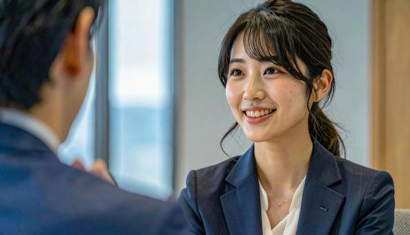 笑顔で話すスーツ姿の女性の写真