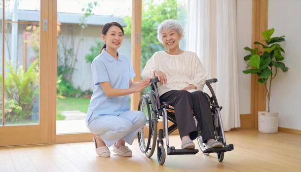 車椅子に乗った高齢女性と女性介護士 車椅子に乗った高齢女性と女性介護士の写真