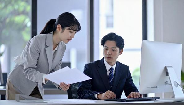 上司に資料を確認する女性社員 上司に資料を確認する女性社員の写真