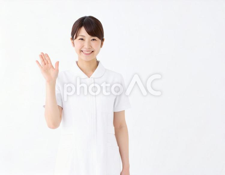 笑顔で手を振る優しい看護師の挨拶シーン 看護師,医療従事者,白衣の写真素材