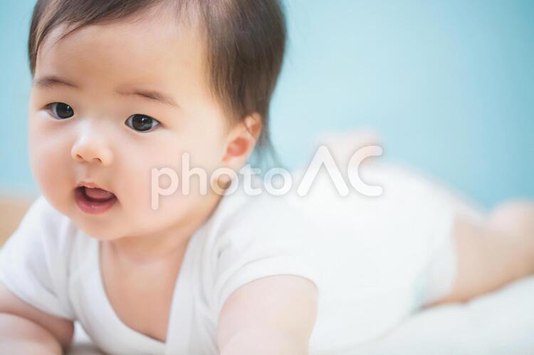 うつ伏せになった笑顔の赤ちゃん 赤ちゃん,赤ん坊,あかんぼうの写真素材