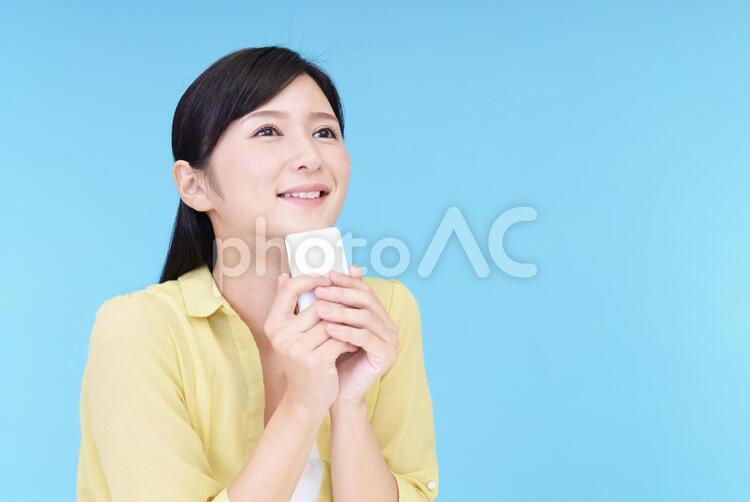 スマートフォンを持つ笑顔の女性 女性,スマートフォン,女の写真素材
