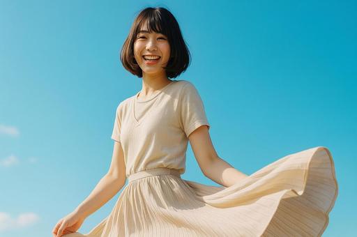 青空の下でスカートを翻して微笑む女性の写真