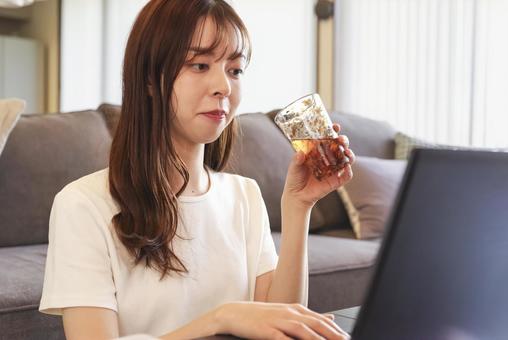 リビングでパソコンを操作する女性 リビングでパソコンを操作する女性 フリーランス,プログラミング,プログラマーの写真素材