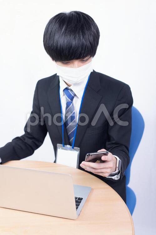 マスクをしてスマートフォンを確認する若い日本人サラリーマン マスク,健康,ヘルスケアの写真素材