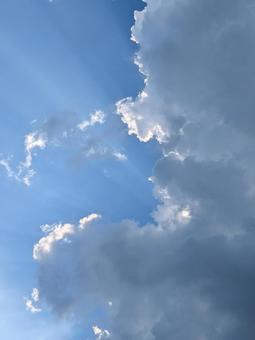 雲間から射す日の光と青空(縦向き) 雲間から射す日の光と青空(縦向き)の写真