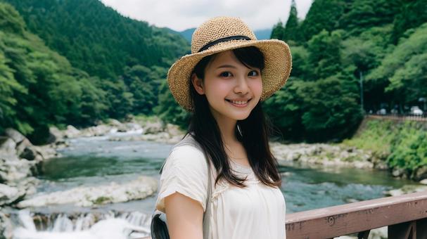 夏の渓流沿いの遊歩道に立つ若い日本人女性 夏の渓流沿いの遊歩道に立つ若い日本人女性の写真